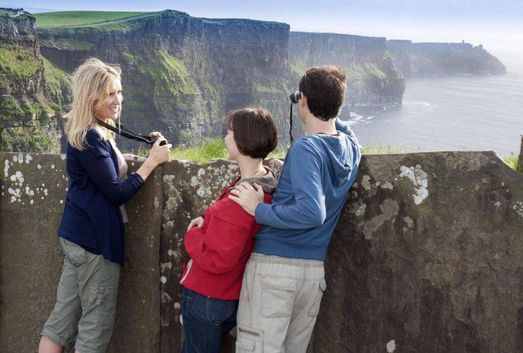 Tres estudiantes de inglés adultos mirando hacia los acantilados de Moher