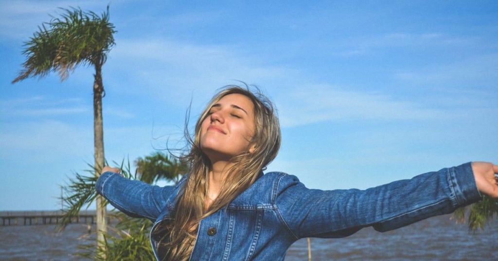 mujer joven contenta con abrazos abiertas