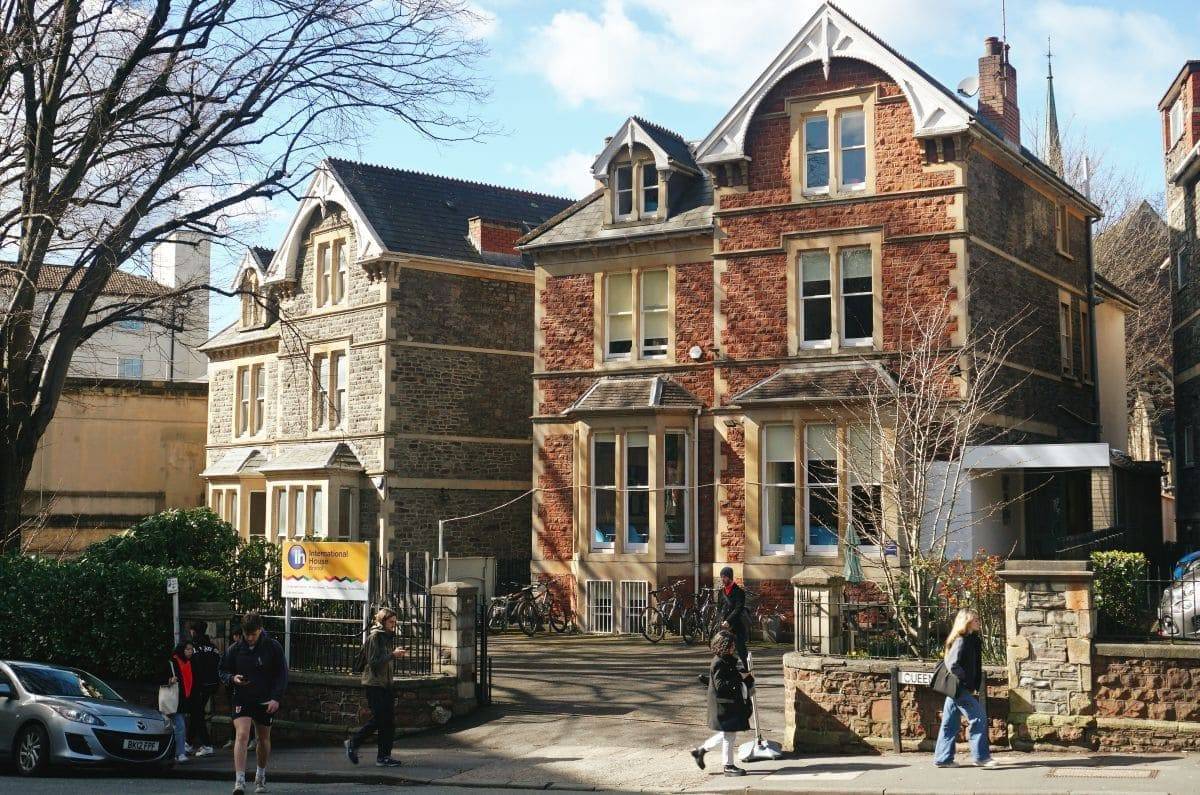 Fachada de la escuela de cursos de inglés en Bristol para adultos bajo el sol con estudiantes pasando