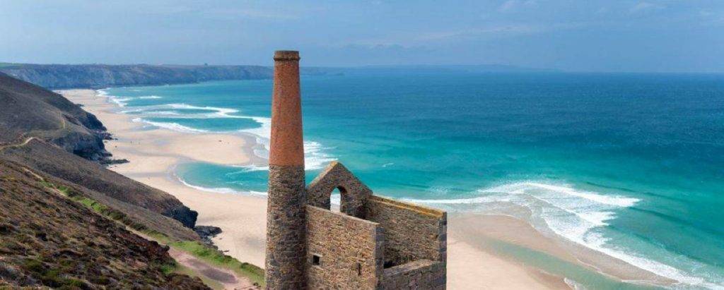 Mina de estaño antigua en Cornwall, con el mar al fondo.