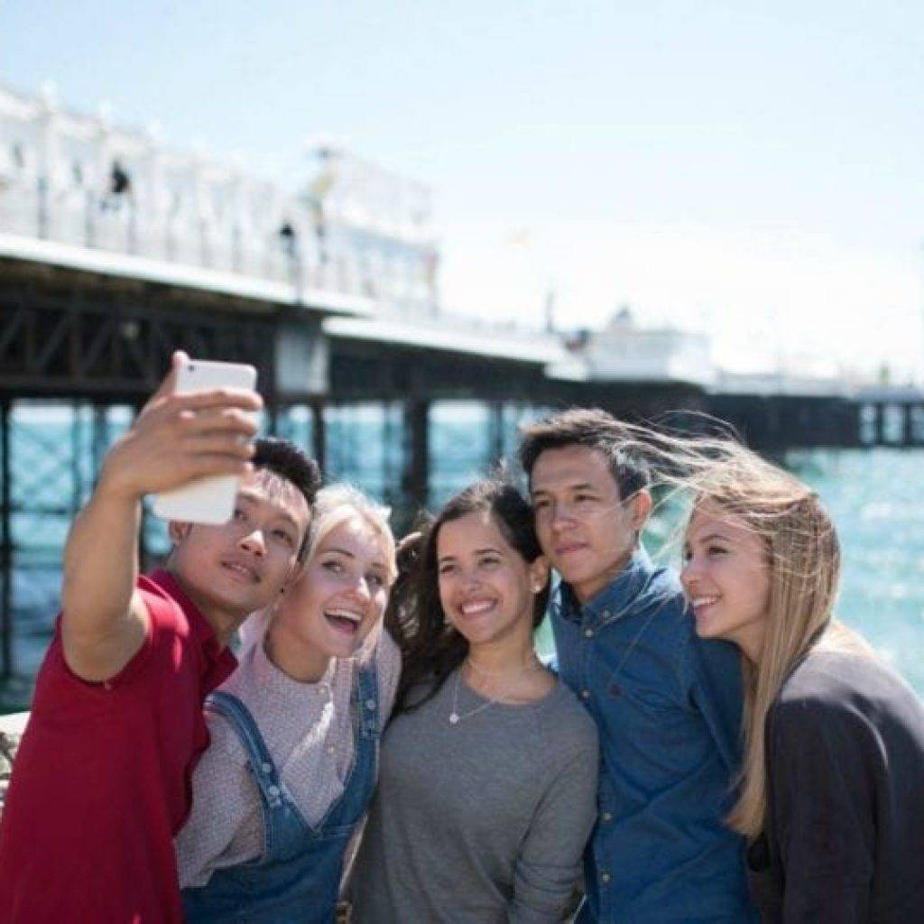 estudiantes de inglés en Brighton B2 C1, sacando un selfie con el muelle al fondo