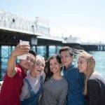 estudiantes sacando un selfie con el muelle de Brighton al fondo