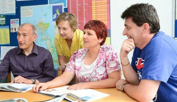 profesora y 3 estudiantes estudiando un cursos de inglés para principiantes en el extranjero