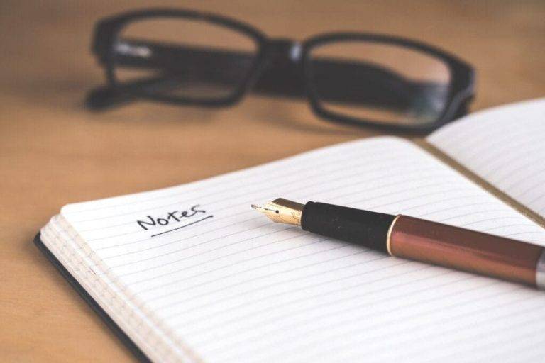 un bolígrafo, cuaderno y gafas de un profesor | enseñar inglés online