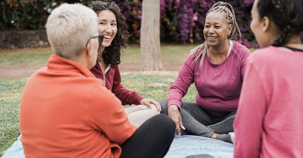 mujeres sentados disfrutando conversaciones en inglés en un parque
