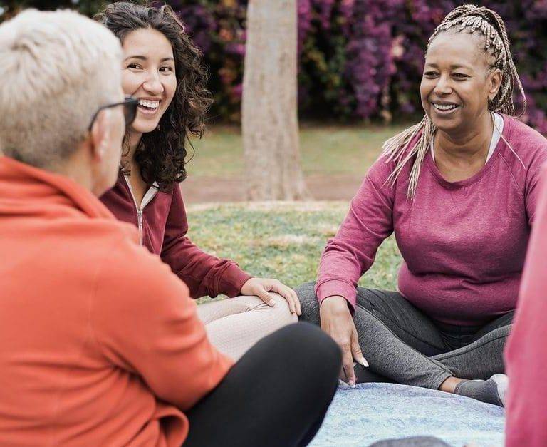 mujeres sentados disfrutando conversaciones en inglés en un parque