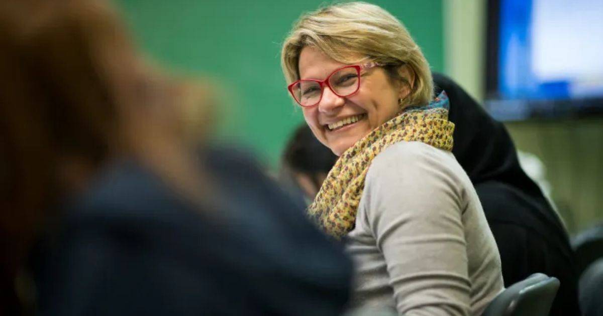 mujer sonriendo durante una clase de inglés de negocios en Estados Unidos