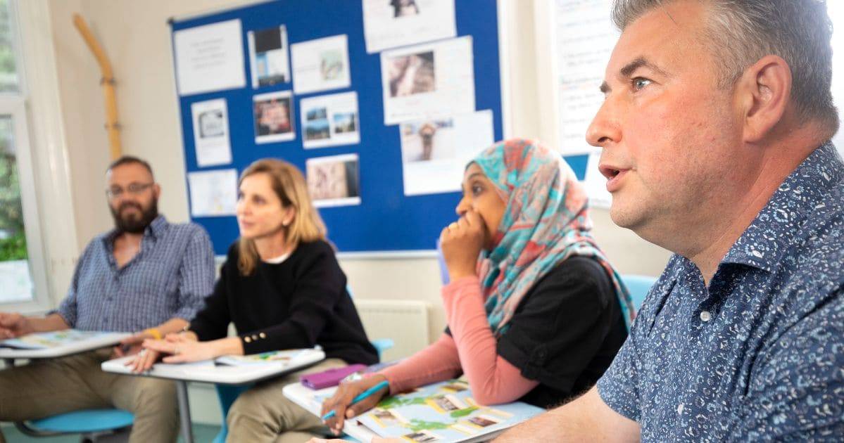 4 estudiantes sentados en su aula durante sus cursos de inglés para adultos en Bristol