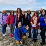 Grupo de estudiantes de inglés mayores de 50 años, de excursión posando para una foto con el río Corrib (Galway) al fondo