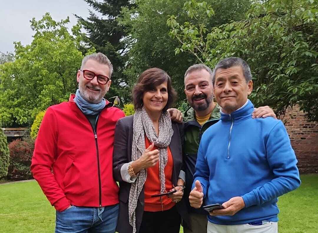 cuatro estudiantes mayores de 50 años sonriendo en la jardín de su escuela en York