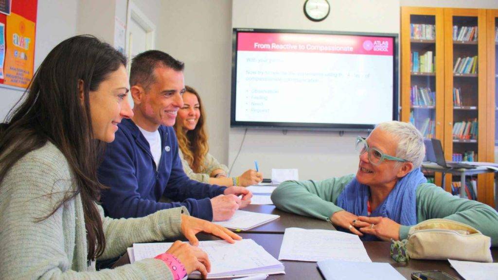 estuidiantes de inglés para adultos en Dublín Irlanda sonriendo con la profesora en el aula.